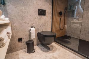 a bathroom with a black toilet and a shower at Hotel zum Kaiserdom in Speyer +16 photos