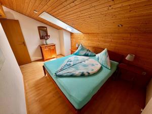 a bed in a room with a wooden ceiling at Landhaus Zoppoth in Kötschach