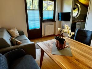 a living room with a couch and a table with flowers on it at Landhaus Zoppoth in Kötschach
