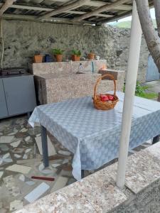a picnic table with a basket of fruit on it at Guest house Tea in Kvareli