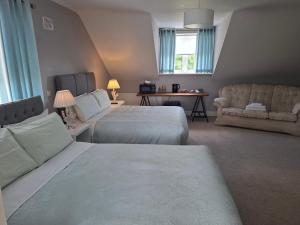 a hotel room with two beds and a couch at White Quarry Hse Quarry Road in Navan