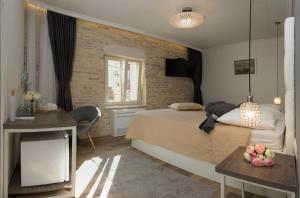 a hotel room with a bed and a desk and a window at Aspalathos Residence in Split
