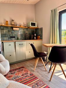 a kitchen with a table and chairs and a microwave at Luxus Kutsche in Grafengehaig