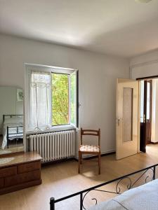 a living room with a chair and a window at Alta Valle Intelvi LA MARINELLA in Lanzo dʼIntelvi