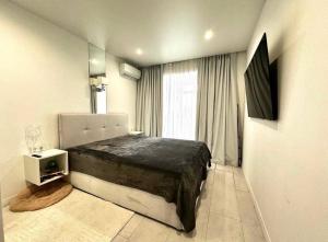 a bedroom with a large bed and a window at Білі апартаменти in Dnipro