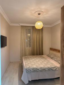 a bedroom with a bed and a chandelier at Vacation Home Nukri in Gonio