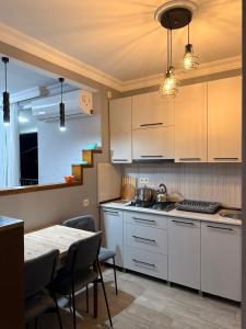 a kitchen with white cabinets and a table with chairs at Vacation Home Nukri in Gonio