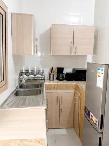 a small kitchen with a sink and a refrigerator at Résidence Senghor - THIÈS in Thiès