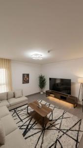 a living room with a couch and a coffee table at 3BDS Luxury Stay Apartment - شقة 3 غرف للإقامة الفاخرة in Jeddah