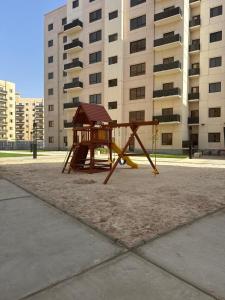 a playground in front of a tall building at 3BDS Luxury Stay Apartment - شقة 3 غرف للإقامة الفاخرة in Jeddah