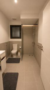 a bathroom with a toilet and a shower with a television at 3BDS Luxury Stay Apartment - شقة 3 غرف للإقامة الفاخرة in Jeddah +7 photos