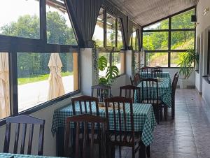 a restaurant with tables and chairs and windows at Jasen restoran in Jarmenovci +7 photos