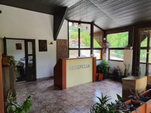 a lobby with a reception desk and plants at Jasen restoran in Jarmenovci