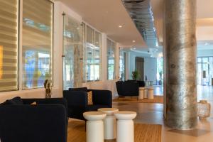 a lobby with couches and chairs in a building at Hotel Riviera in Mamaia
