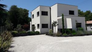 a white house sitting on top of a gravel driveway at Villa proche de Bordeaux in Gradignan