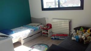 a small bedroom with two beds and a window at Villa proche de Bordeaux in Gradignan