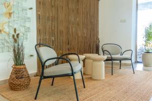 a room with three chairs and a table and a vase at Hotel Riviera in Mamaia