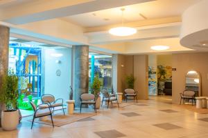 a lobby of a hospital with chairs and tables at Hotel Riviera in Mamaia