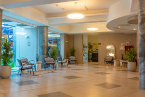 a lobby with chairs and tables in a building at Hotel Riviera in Mamaia