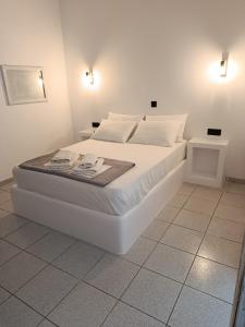 a white bed with white sheets and pillows on it at Anastasia in Aliko Beach