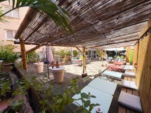 an outdoor patio with a wooden pergola and plants at Mercure Toulouse Centre Wilson Capitole in Toulouse