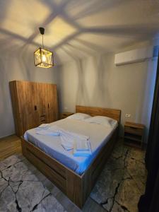 a bedroom with a bed with blue sheets and a ceiling at N'Shkoder in Shkodër