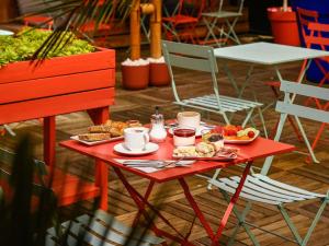 a red table with food on it with chairs at Mercure Toulouse Centre Wilson Capitole in Toulouse