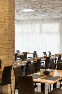 eine Reihe von Tischen und Stühlen in einem Raum mit Fenstern in der Unterkunft Hotel Antoniana in Caorle