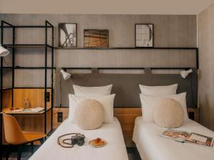 a bedroom with two beds and a table with a camera at ibis Paris Bastille Opera in Paris +99 photos