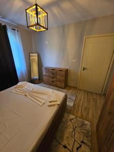 a bedroom with a bed and a chandelier at N'Shkoder in Shkodër +2 photos