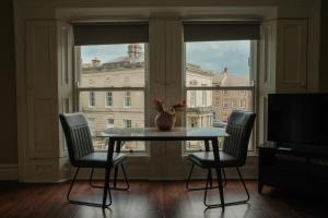 a table and chairs in a room with a window at Flat 4, 2 Victoria Street in Armagh