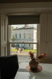 a table with a vase of flowers on a window at Flat 4, 2 Victoria Street in Armagh