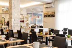 ein Restaurant mit Holztischen und -stühlen in der Unterkunft Hotel Antoniana in Caorle