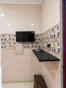 a room with a wall with a tv on a wall at C Gowri Lodge in Vellore +27 photos