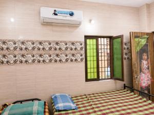 a bedroom with a bed and a tv on the wall at C Gowri Lodge in Vellore