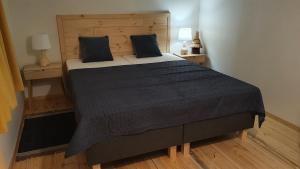 a large bed in a room with two night stands at Forest Edge Retreat in Wizna