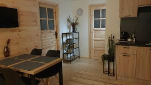 a dining room with a table and a kitchen at Forest Edge Retreat in Wizna