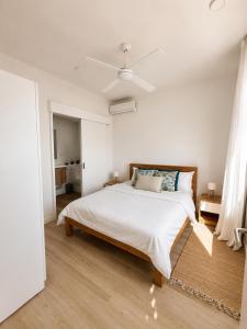a white bedroom with a bed and a ceiling at Blue Zebra - Le West 24 in Tamarin