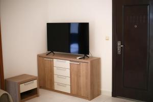 a flat screen tv sitting on top of a wooden cabinet at Apartman Vujović Orahovac in Trstenik +8 photos