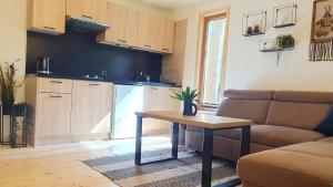a kitchen with a couch and a table in a living room at Forest Edge Retreat in Wizna +19 photos