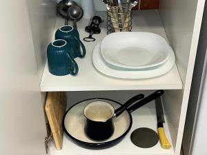 a shelf with a pot and plates on it at 'MONAS' mini apartments in Sombor +38 photos
