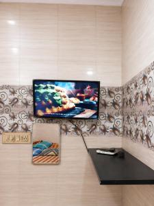 a flat screen tv hanging on a wall at C Gowri Lodge in Vellore