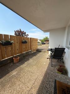 a patio with a chair next to a fence at Moderne Ferienwohnung mit guter Ausstattung und Self checkin in Bodenwerder +6 photos