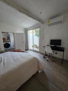 ein Schlafzimmer mit Bett, Schreibtisch und Computer in der Unterkunft GARÍ Loft in Chihuahua