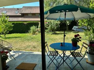 a table with an umbrella on a patio at Appartement 55 m2 proche de la plage in Sévrier +10 photos