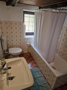 a bathroom with a sink and a tub and a toilet at Casa Grande in Falmenta