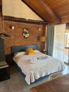 ein Schlafzimmer mit einem Bett vor einer Ziegelwand in der Unterkunft La Buschera in Bra