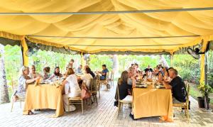 a group of people sitting at tables under a tent at Pavana Hotel Negombo in Negombo