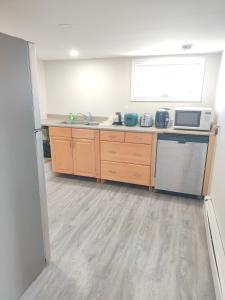a kitchen with wooden cabinets and a sink and a window at Central Light-Filled 3rd Floor -3C in Halifax +13 photos
