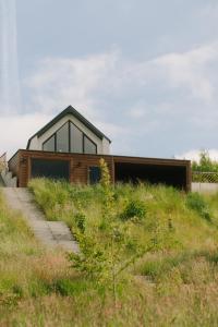 a house on top of a grassy hill at Raduńskie Zacisze in Chmielno +113 photos